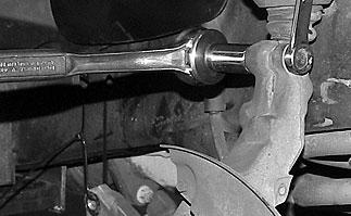 Remove the cotter pin and castle nut from the tie rod end at the spindle. Separate the tie rod end from the spindle using a tie rod puller.