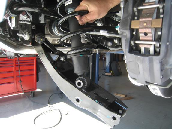 Place the strut in a spring compressor and remove