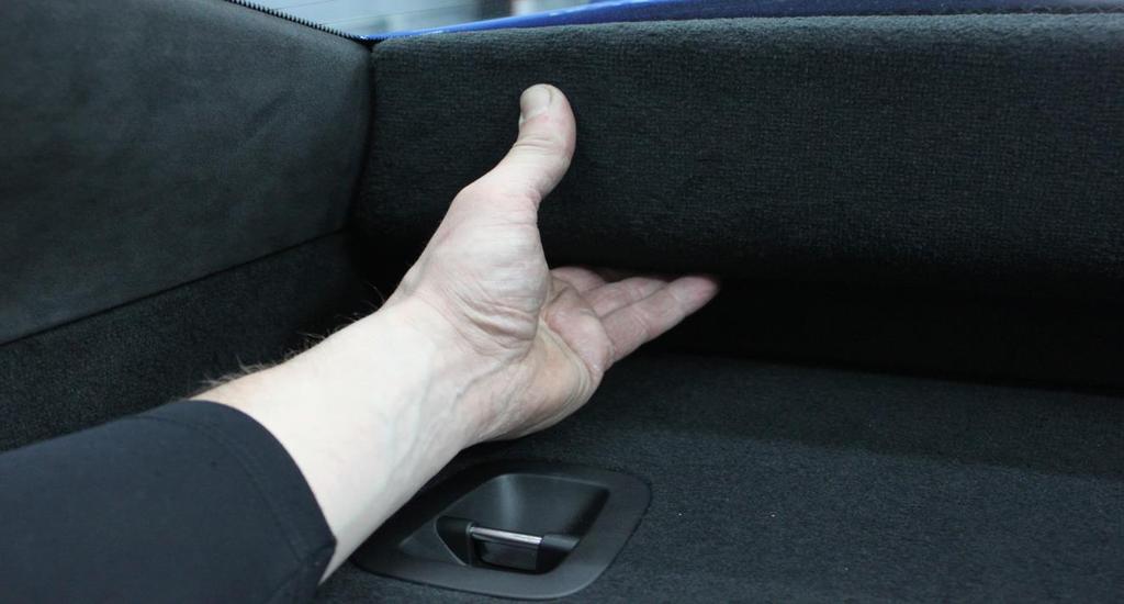 5. Below the rear window is a carpeted piece that pulls out straight towards the