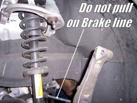 Be careful not to let the steering knuckle assembly pull on the brake lines.