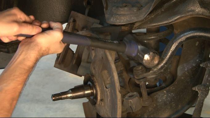 Using 21mm wrench, loosen upper ball joint nut.