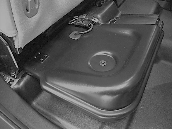 4. Connect the subwoofer wiring to the subwoofer harness and set the enclosure into place by sliding the center bracket through the slit in the carpet and over the seat stud and seatbelt receptacle