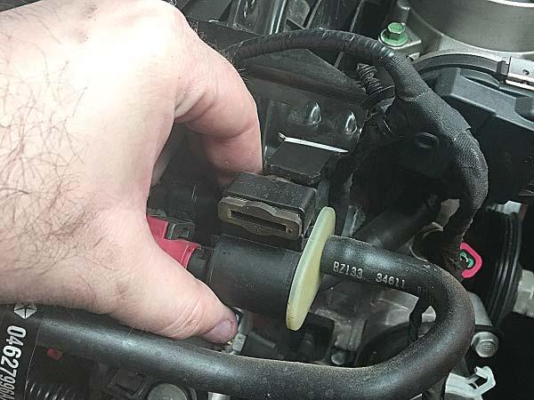 Disconnect the hoses, and electrical connector from the EVAP sensor and