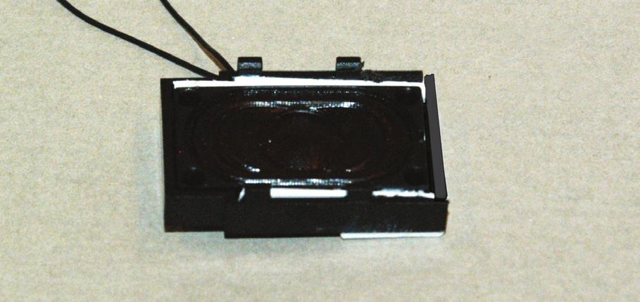 15. There are two clips on each side of the speaker enclosure on the front of the model. Spread the clips and lift the enclosure off of the model. Remove the weights from the inside. 16.