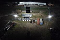 The right image shows the WCDE-20-HLM65-20X500LTL-LED-WSM light plant raised to 50`, illuminating the same 50,000 square foot work area with twenty 480 watt LED fixtures.