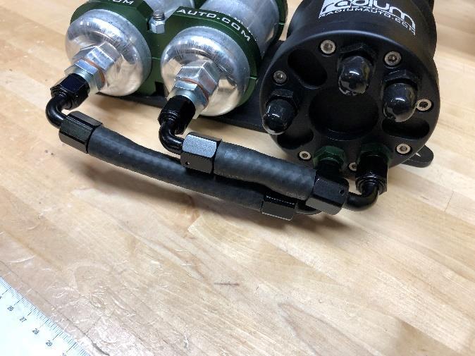 Using a non-marring aluminum wrench, attach the 2 included fuel hoses from the FST green ports to the pumps and tighten.