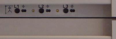 Insert the voltage indicator successively in all three busbar test sockets of the phases L1, L2, L3 (on the right side of the panel).