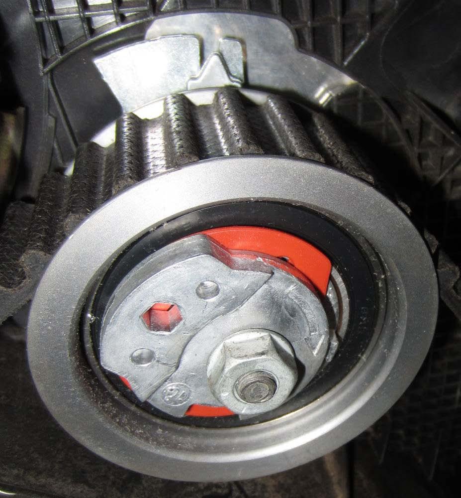 59. Rotate tensioner clockwise until indicator aligns with the slot on the tensioner backplate and