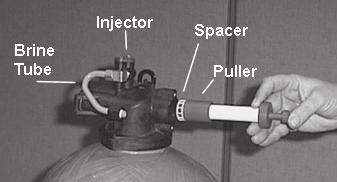 They are retracted or pushed out by pulling or pushing the center button the opposite end. 8. Insert the pin end of the spacer tool into the valve body with the pins retracted (button pulled back).