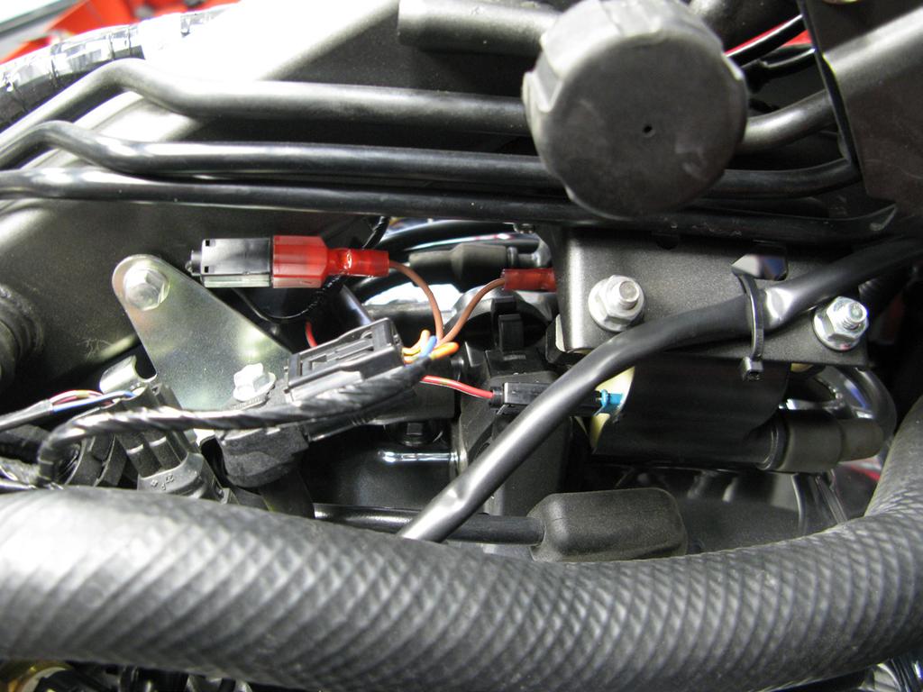 Locate the factory front ingnition coil, and disconnect the factory black/orange wire from the coil, and install the Bazzaz coil connectors inline. 4.