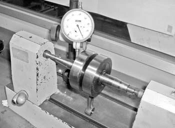 - Fit the crankshaft onto a lathe and turn it, checking the gap between its crank blades with the aid of a pair of comparison meters placed perpendicularly