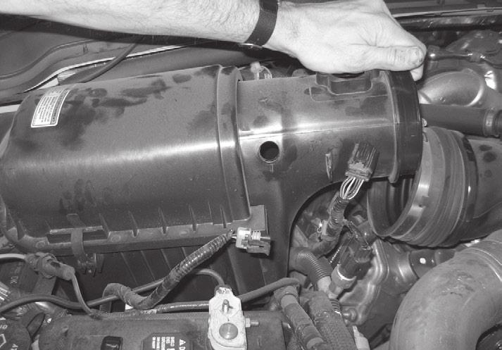 9. Push the air cleaner bellows away from the air filter housing while pulling up on the MAF side of the air filter. Lift and remove the air filter housing in the direction shown in Figure 7. 10.