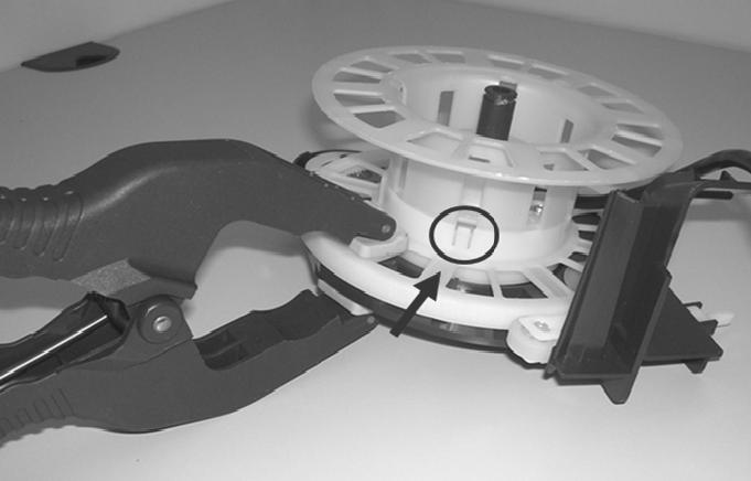 Figure 010-10: Cord Reel Tabs 6. Remove the cord from the cord reel. 7. Install the new cord. 8. Reassemble the reel halves. Do not remove the clamp until the cord reel halves are fully assembled. 9.