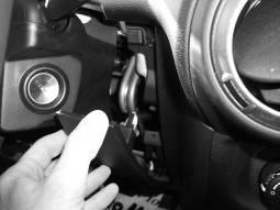 Remove the two 7mm screws (one on each side of the steering column) that secure the