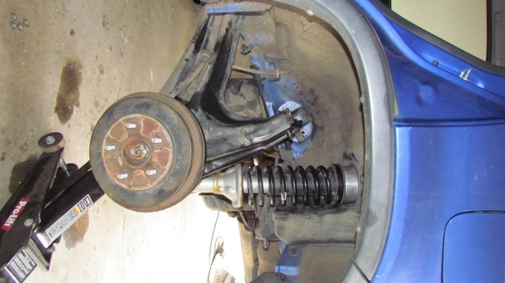 13. In either case, you should now have the spacer securely mounted to the top of the spring seat and the strut re-aligned in the wheel well.