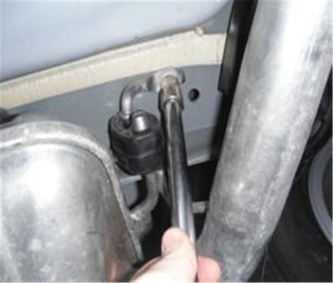 Locate and remove (2) exhaust isolators near muffler on driver and passenger