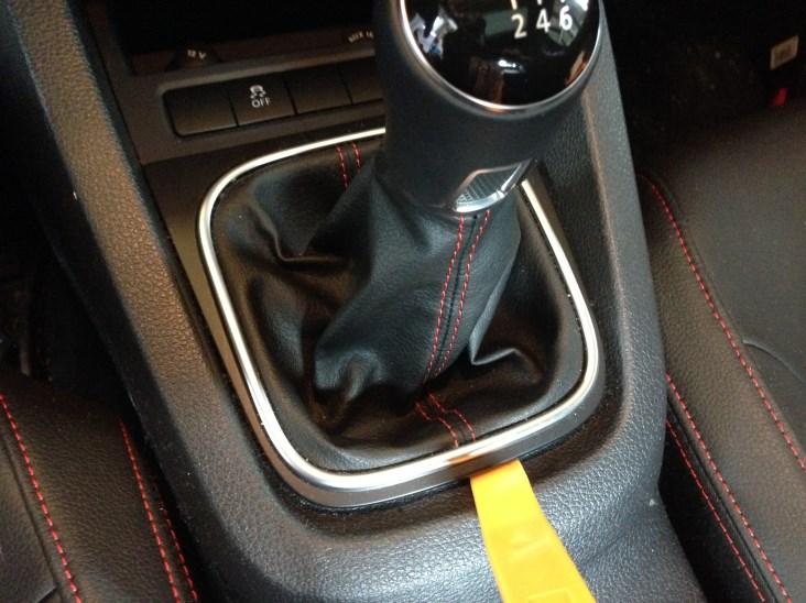 It may also be possible to grasp the edges of the trim surrounding the shifter, where it