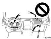 Do not put anything or any part of your body on or in front of the dashboard or steering wheel pad that houses the front airbag system.