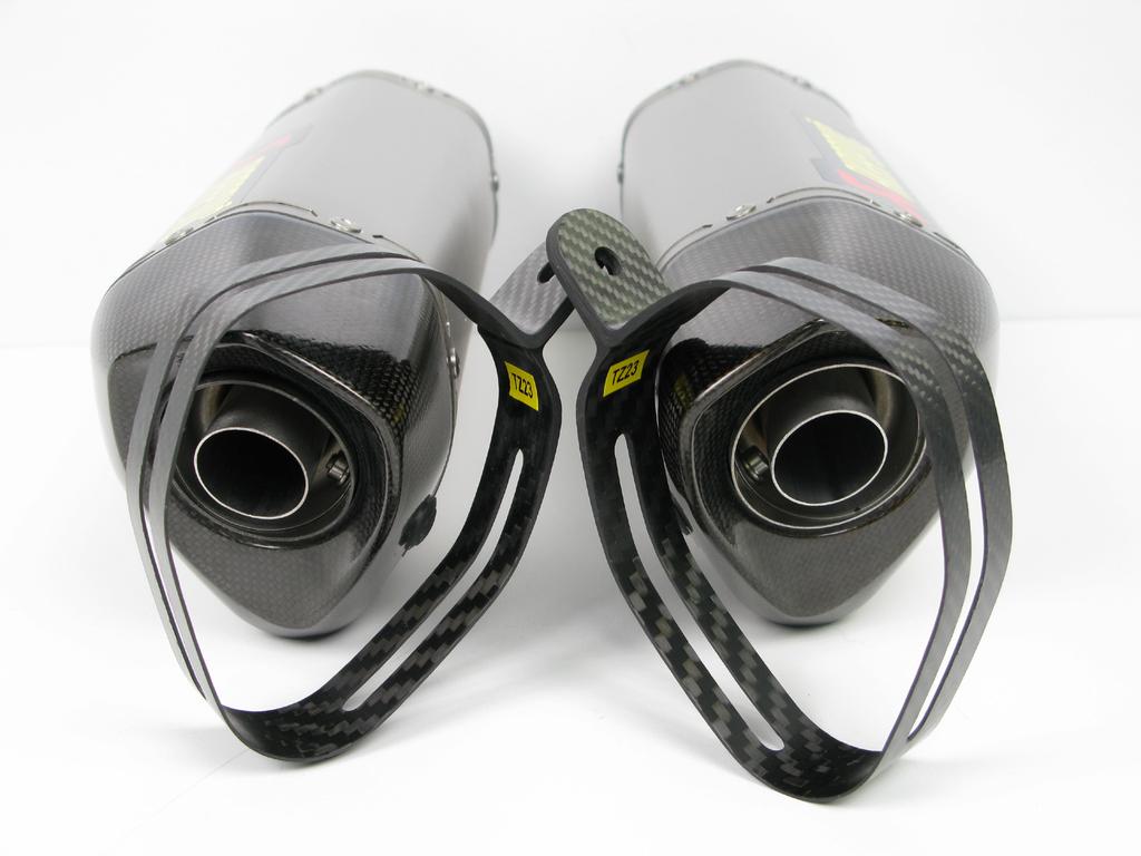 Correctly position the carbon-fiber clamps and slide them onto the mufflers - bear in mind the left offset of the carbon-fiber clamp viewed from