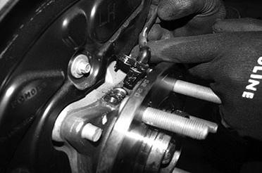 Remove the brake caliper and place it next to the frame. Do not overstretch the brake hose when doing so. Retain the hardware for reinstallation.