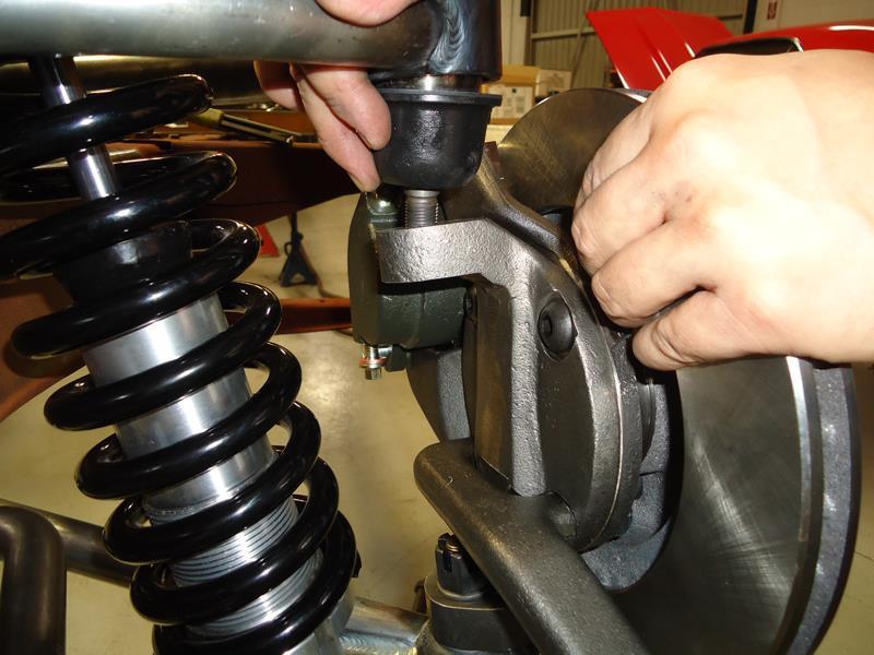 (the tie rod end goes up into the steering arm) Place the ball joint washer first and then the castle nut. Torque the lower ball joint to 90 ft. lbs and install the cotter pin.