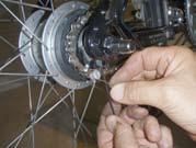 Pull the wheel rerwrd to mke the chin tut nd center the wheel, then tighten the hu nuts using the 15 mm open end wrench