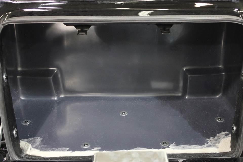 Inside the trunk, pull back the carpet and remove the five bolts that secure the body to the frame.