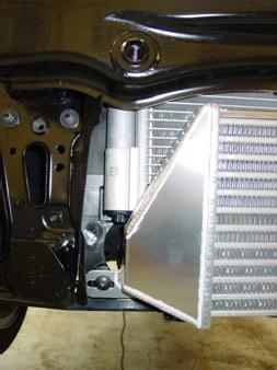 On the lower edge of the black plastic front panel there are slots that the intercooler end tanks will
