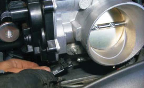 52. Using a long pair of pliers, remove the coolant hoses from the bottom of the throttle