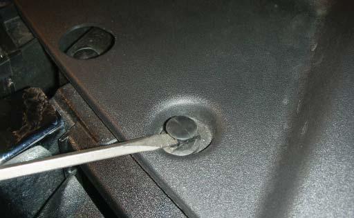 Using a fl at blade screwdriver, remove the eight plastic pushpins from the radiator