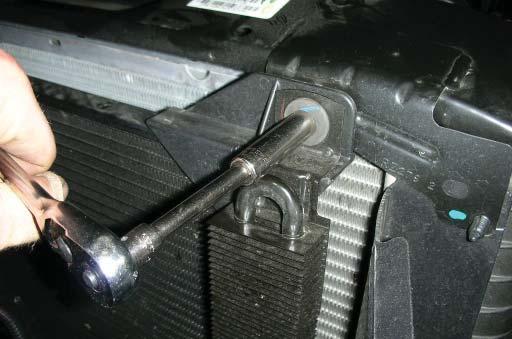 Using a 10mm socket wrench, remove the two bolts that hold the power steering cooler in