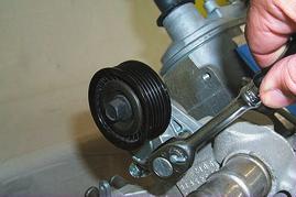 75. Remove the stock belt tensioner assembly by removing the two