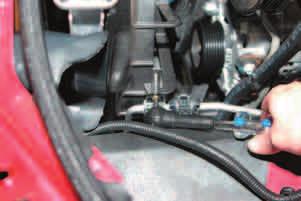 81. On the left side of the engine, remove the A/C pipe support tab from the fan