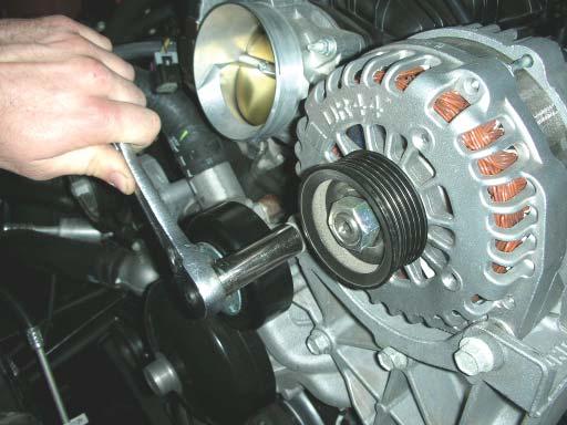 Using a 15mm socket wrench, remove the two bolts securing the alternator to the