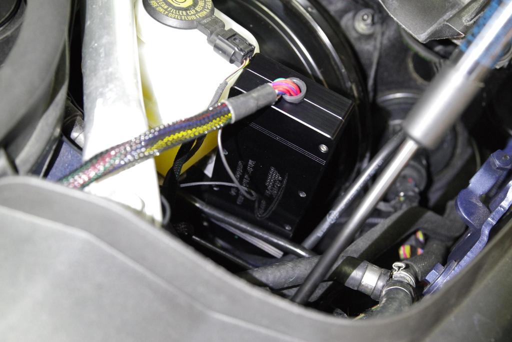 Insert the control box near the brake booster as shown.