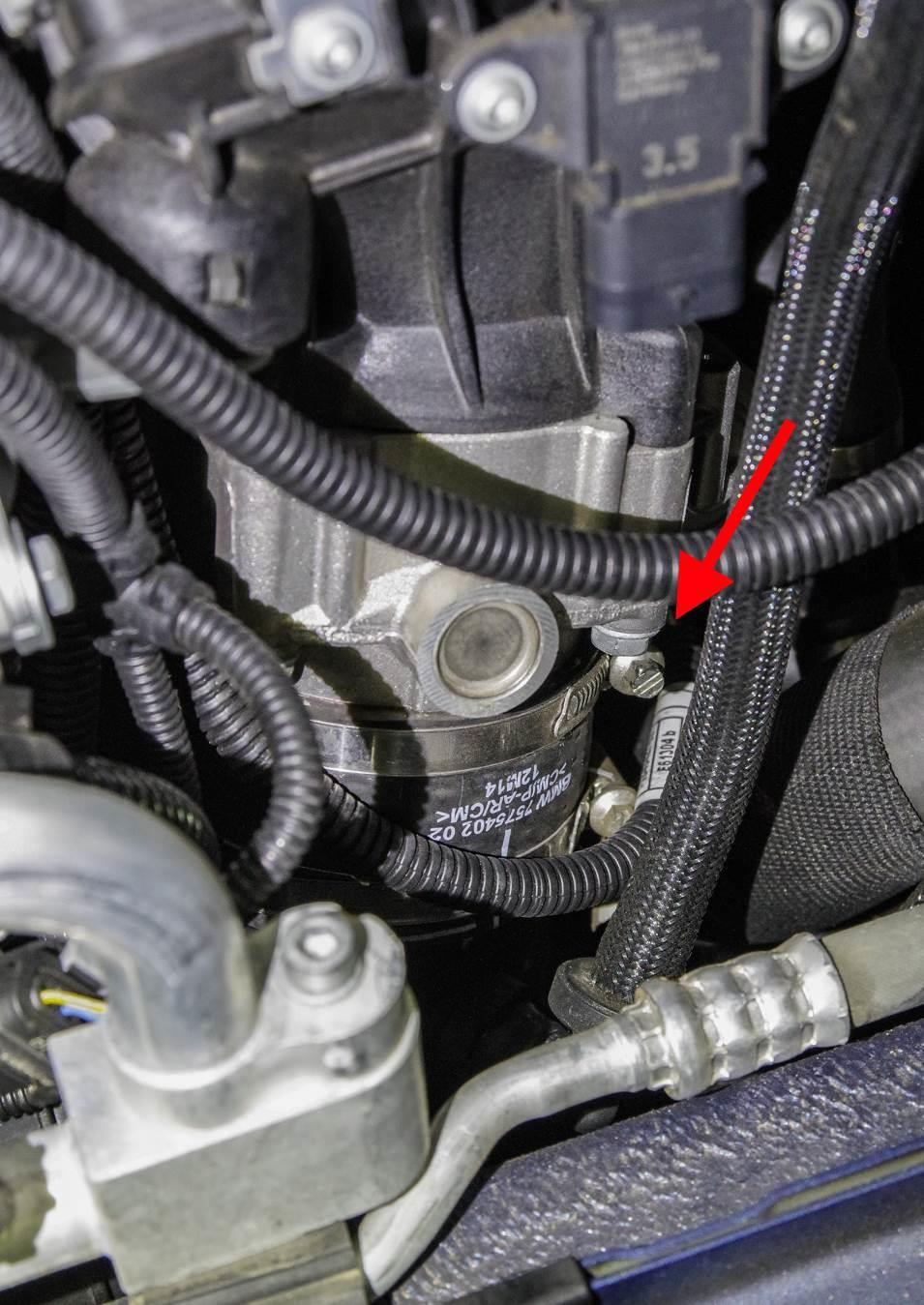 Near the TMAP sensor on the passenger side, find the top clamp holding the intercooler to the intake manifold via the rubber coupling.