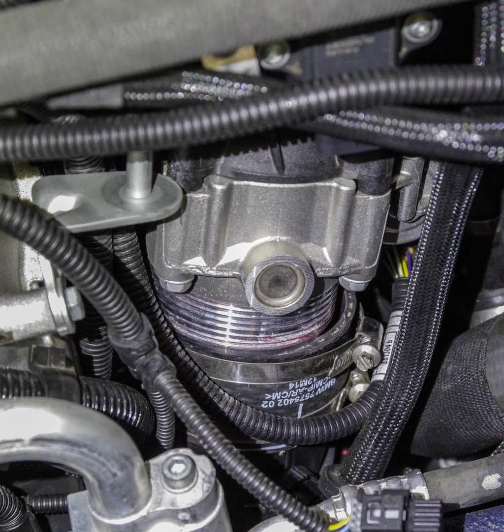 With the brace out of the way or coolant lines disconnected, you can now move the intercooler up enough to gain access to