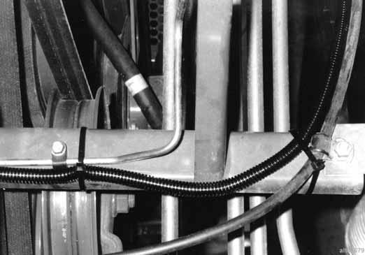 Place a long, thin rod between the cab and grain tank from right side of combine. Push rod through to left side of combine. g. Tape end of elevator speed cable to rod and pull cable through to right side of combine.
