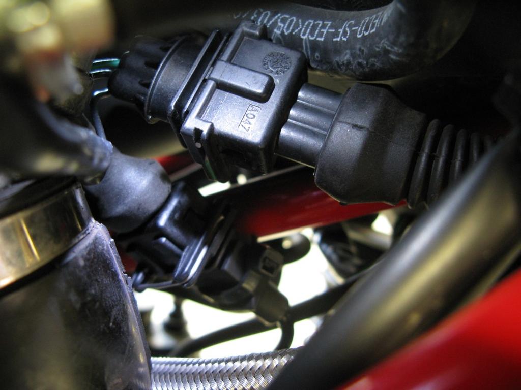 Locate the injector for the front cylinder, found on the right side of the throttle bodies just inside of the frame rail.
