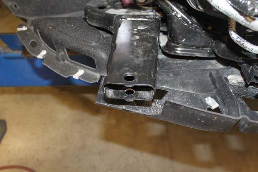 Using a 1/2 drill bit, ream the lower existing hole in the frame extension. Do this on both sides of the vehicle.