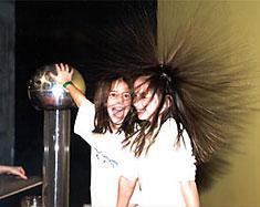 The van de Graaf generator (large silver ball) deposits electrons on the ball.