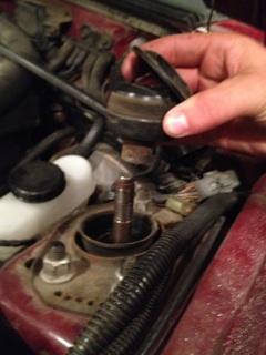 Step 11 continued: With the nut off remove the top cap and bushing from the strut shaft.