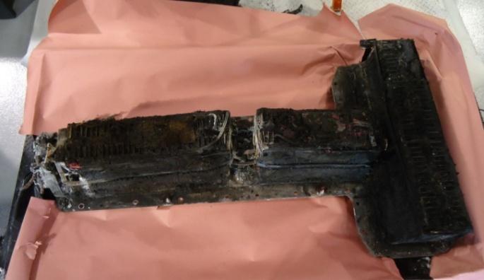 3-5 (right photograph). As a reference, an unburned battery is shown in the photograph on the left (Figure 3.3-5). As shown in this figure, the battery was still fairly intact after the fire.