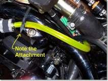 Turn and route the line under the large filler neck beside the new L connector then turn up between the frame rail and filler tray, over the frame rail and attach to the New Fuel Filter as shown in
