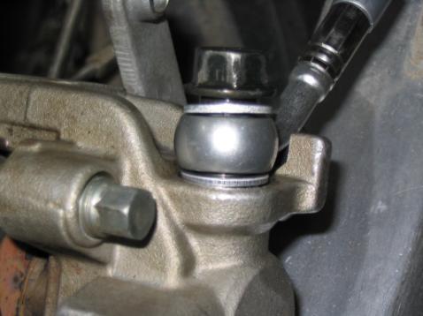 Use your stock banjo bolt to secure the line at the rear caliper. Replace the two crush washers with the two included crush washers and torque to 15-20nm. See picture below.