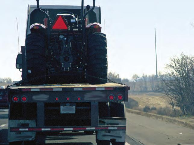 A single slow moving vehicle (SMV) sign on a tractor meets the legal requirement if the equipment in tow does not obscure it.