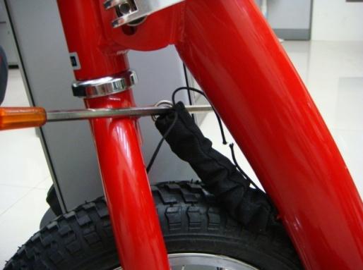 3) Use a long screw driver, pliers or small pry bar to attach opposite end of Steering Centering Spring to eyelet on front fork as