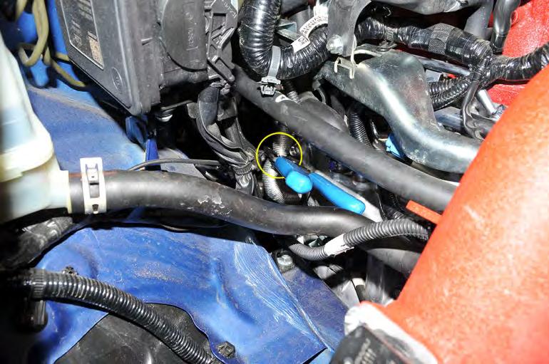 28. To minimize coolant loss, pinch off the lower coolant hose that connects the