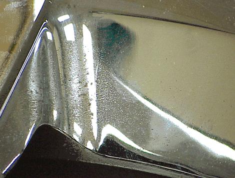 A third type of finish disturbance results from prolonged exposure to brake dust and resultant penetration of brake dust through the chrome.