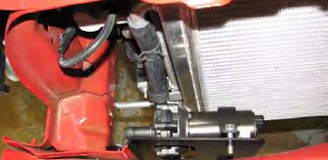 Slide an extra clamp onto the outlet hose, then install the water pump and bracket by sliding it over the two inside bumper